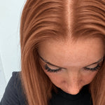 Close-up of the natural lace hairline and parting on a Copper Glow human hair wig in bright copper red