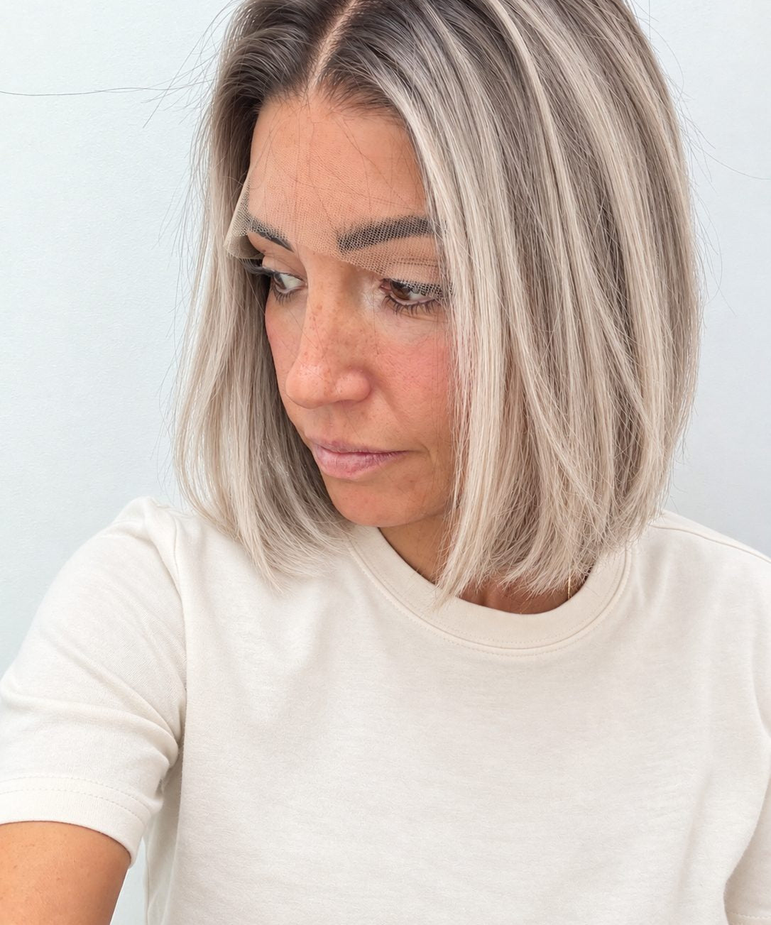 Nordic Pearl 10-inch blunt bob wig in rooted platinum blonde, side view showing the hairline
