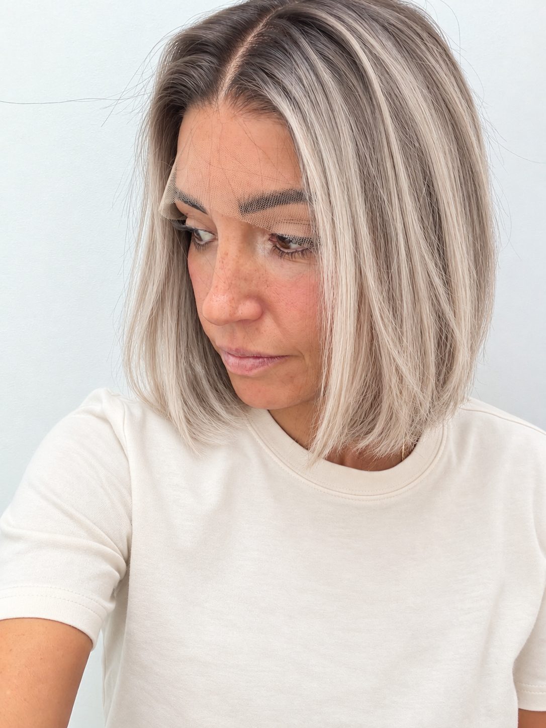 Nordic Pearl 10-inch blunt bob wig in rooted platinum blonde, side view showing the hairline