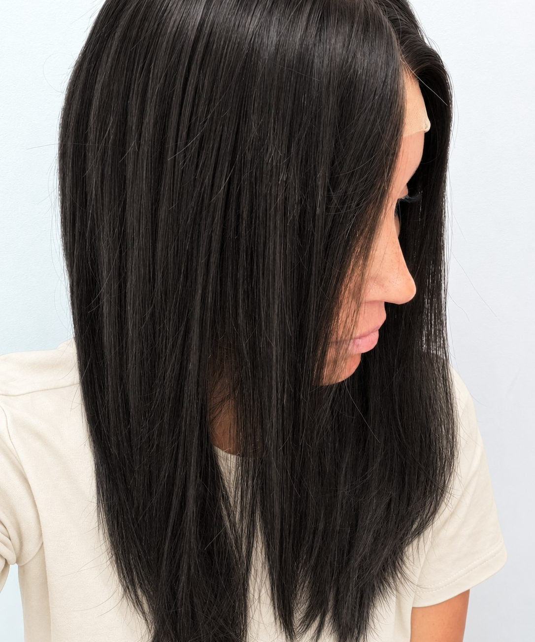 Soft Onyx 18-inch layered straight wig in soft natural black, side view showing the hairline