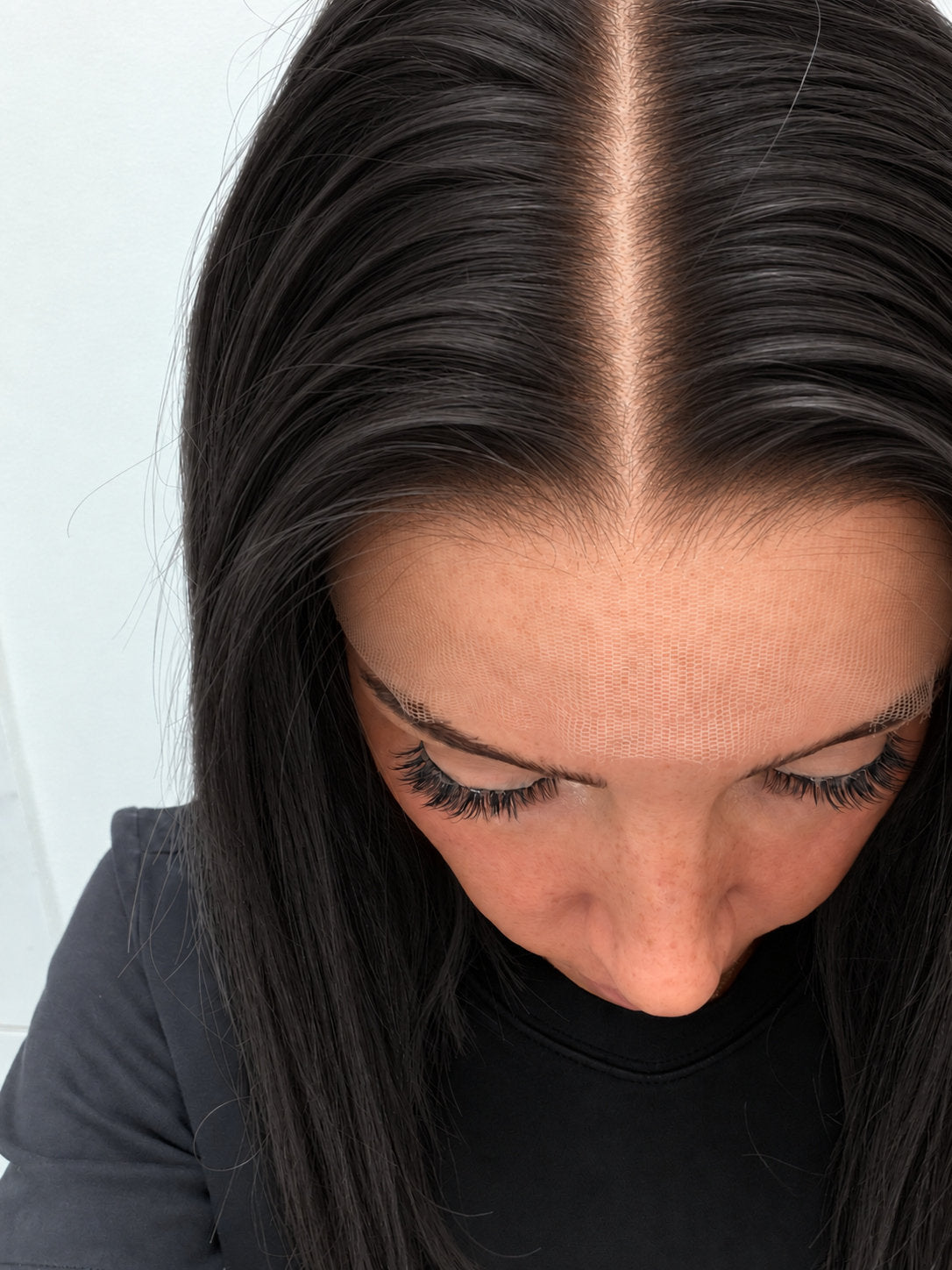 Close-up of the natural lace hairline and parting on a Soft Onyx human hair wig in soft natural black