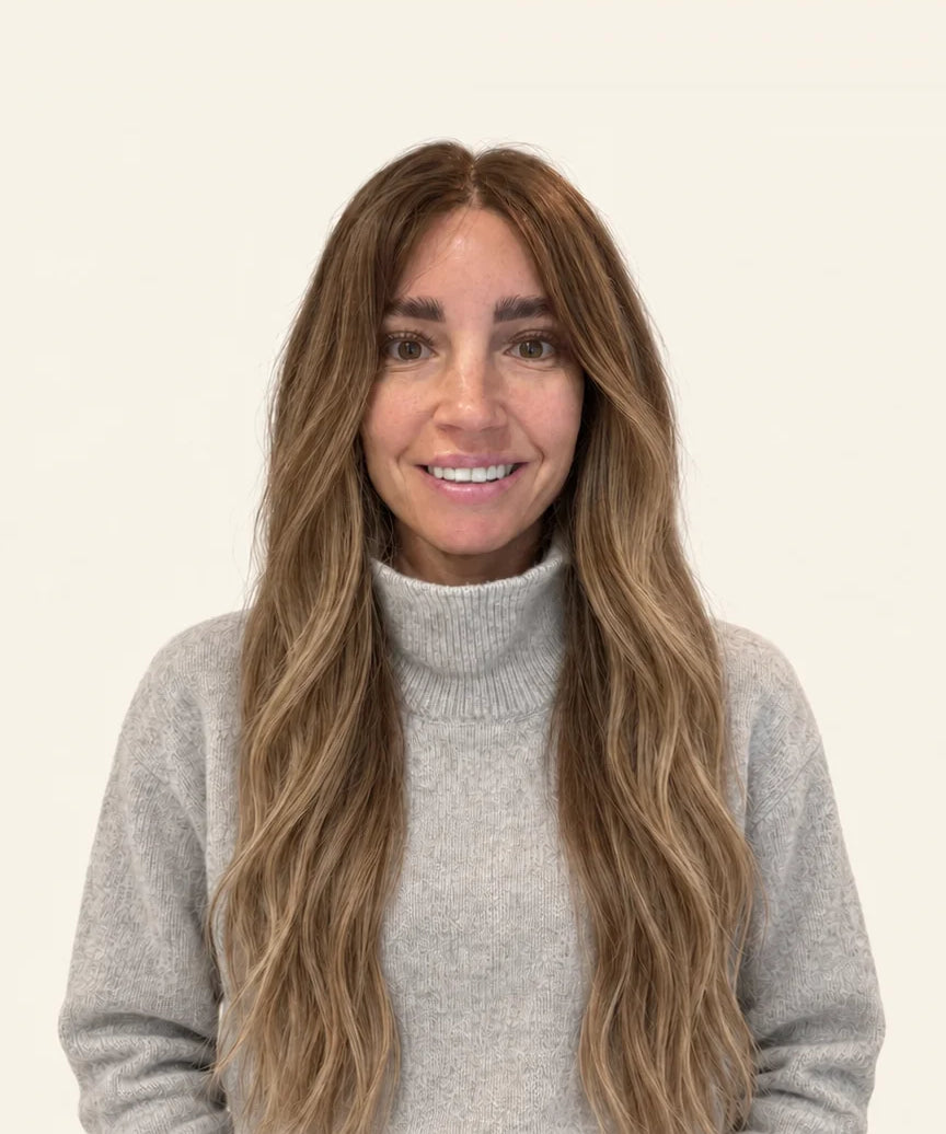 Woman in a grey jumper wearing the 24-inch Maxi human hair wig, front view showing where the 24-inch length falls